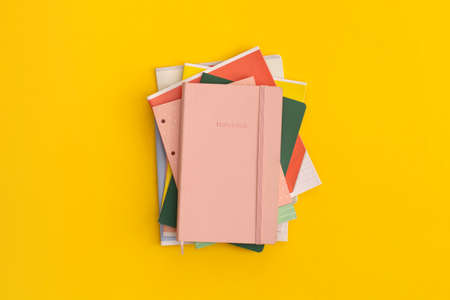 Notebooks on yellow background. Top view. Flat lay. Back to school concept.