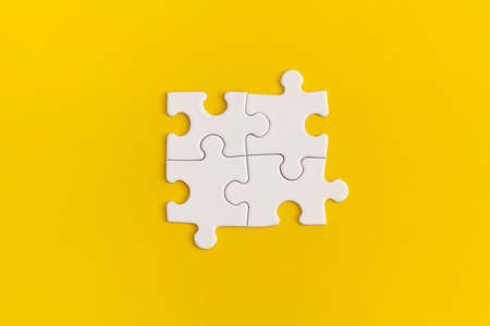 White details of puzzle on yellow background.の写真素材