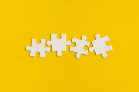 White details of puzzle on yellow background.の写真素材