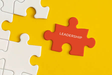 White details of puzzle on yellow background. Business strategy, teamwork, leadership.の写真素材