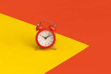 Red alarm clock on color backgroundの写真素材