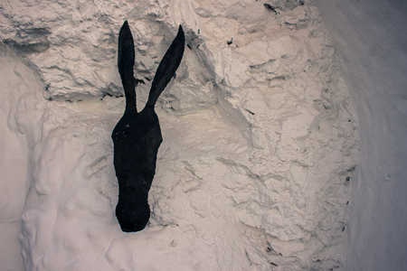 Donkey. A black metal donkey on a white wall. Mijas, Andalusia, Spain.の写真素材