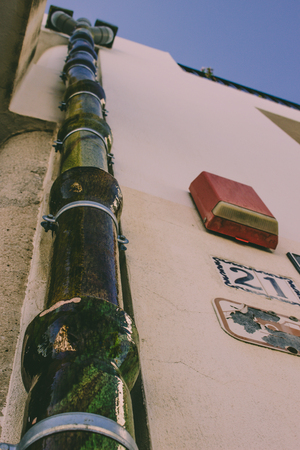 Drain An unusual ceramic gutter green on a white wall. Mijas, Andalusia, Spain.