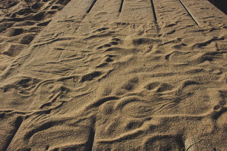 Wooden background. Wooden panels with beach sand and traces.