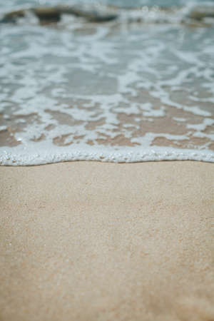 Soft blue ocean wave on sandy beach. Background.