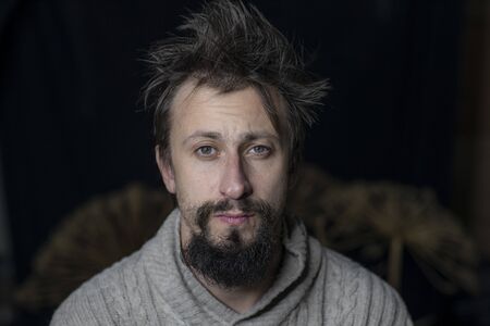a young man with a beard rumpled appearance in a sweater. The fight against alcoholism