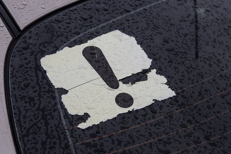 the exclamation mark on the rear window of the car. Attention, young driver