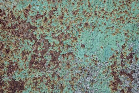 the surface of the old metal, pitted with rust, covered in old green paint