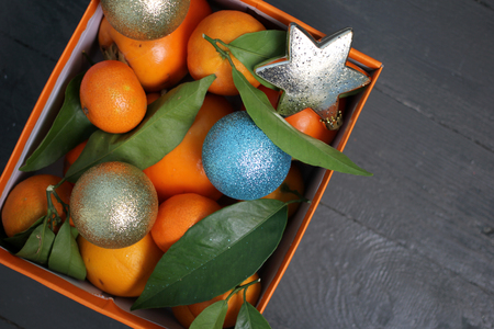 Christmas and New Year: Tangerines and Christmas decorations in a boxの写真素材