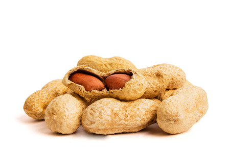 Close up view of shelled peanuts and cracked peanuts isolated on white. Heap of peanuts as...