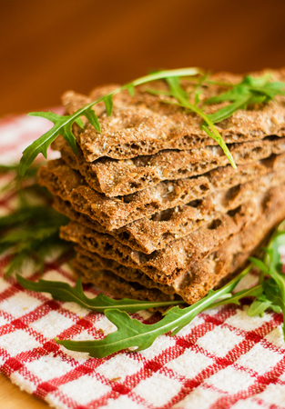 Crispbread with ruccola on tablecloth in red cage. View from above.の写真素材