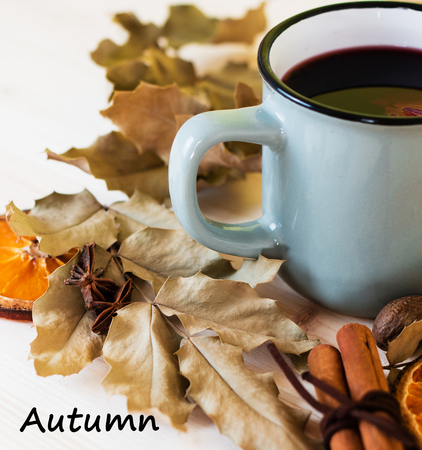 Autumn, fall leaves, hot steaming cup of glint wine on wooden table background. Seasonal, autumnal hot wine, Autumn relaxing and still life concept. Top view with text autumn.の写真素材
