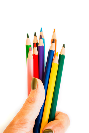 Color pencils in hand isolated on white background. Close up. View from above.の写真素材
