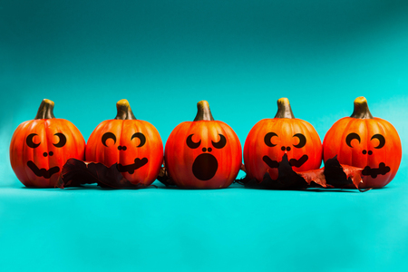 Halloween holiday background. Halloween pumpkin jack o lantern decor with funny faces on blue background. Copy space for text.の写真素材