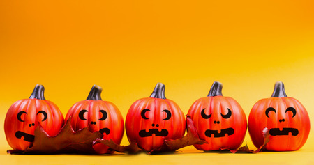 Halloween holiday background. Halloween pumpkin jack o lantern decor with funny faces on yellow background. Copy space for text.の写真素材