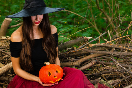 Halloween holiday background. Halloween Witch with a halloween pumpkin jack o lantern decor with...