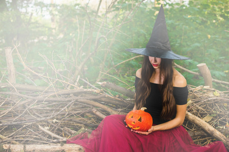 Halloween holiday background. Halloween Witch with a halloween pumpkin jack o lantern decor with...