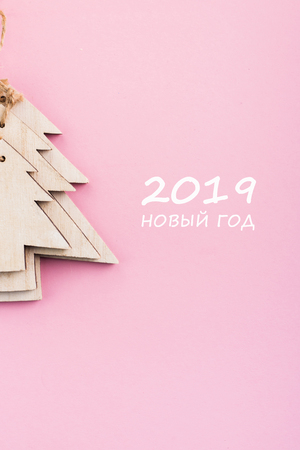 Christmas and New Year's Day festive decoration, wooden Christmas trees on pink background.  Copy space for text. Flat lay. View from above with text 2019 New Year (text in russian).の写真素材