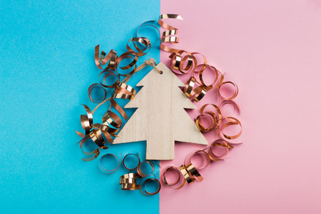 Christmas and New Year's Day festive decoration, wooden Christmas trees with golden ribbons on pink and blue background.  Copy space for text. Flat lay. View from above.の写真素材