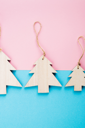 Christmas and New Year's Day festive decoration, wooden Christmas trees on blue and pink background.  Copy space for text. Flat lay. View from above.の写真素材