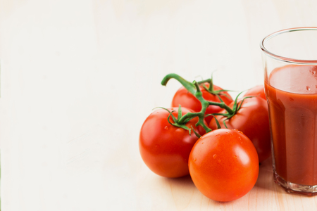 Glass of tomato juice with tomatoes on wooden background, Healthy lifestyle concept. Copy space for text.の写真素材