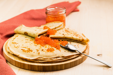 Fresh homemade crepes with red caviar on wooden background. Close-up view. View from above.の写真素材