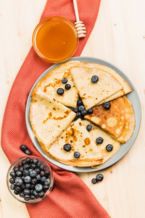 Fresh homemade crepes with blueberry and honey on wooden background. View from above. Copy space for text.の写真素材