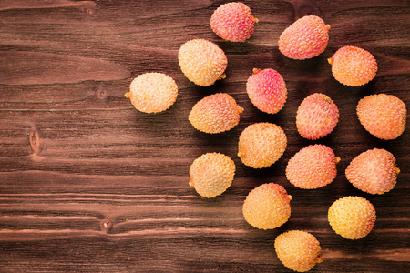 Fresh organic lychee fruits on brown wooden background. Tropical fruit. Macro view. Copy space for text. Top view.の写真素材
