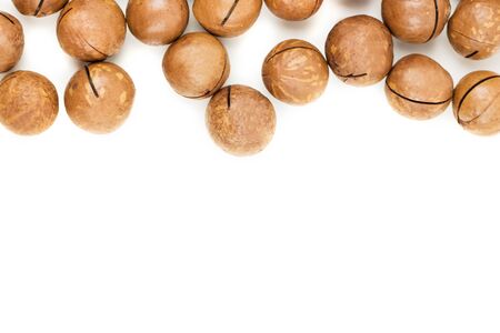 Raw not peeled whole macadamia nuts isolated on white. Macro view. Healthy food. Protein source. Flat lay. View from above with copy space for text.の写真素材