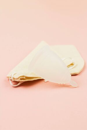 Close up of menstrual cup in cotton bag on pink background with copy space for text. Zero waste alternative and environmentally friendly feminine hygiene product,の写真素材