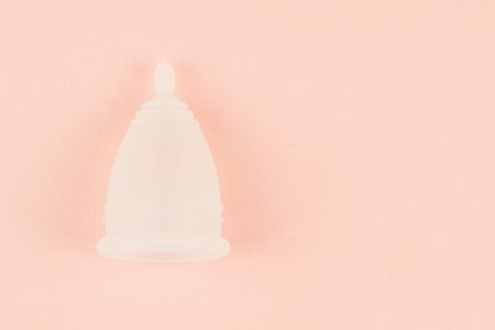 Close up of menstrual cup on pink background with copy space for text. Zero waste alternative and environmentally friendly feminine hygiene product, Top view.の写真素材
