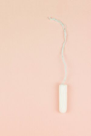 Menstruation cotton tampon on pink background with copy space for text. Feminine hygiene product, View from above.の写真素材