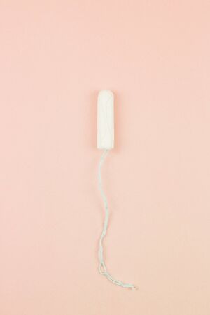 Menstruation cotton tampon on pink background with copy space for text. Feminine hygiene product, View from above.の写真素材