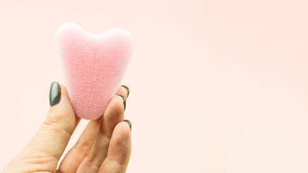 Close up of woman hand holding menstrual sponge tampon on pink background with copy space for text. Feminine hygiene product,の写真素材