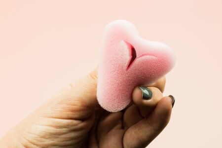 Close up of woman hand holding menstrual sponge tampon on pink background with copy space for text. Feminine hygiene product,の写真素材