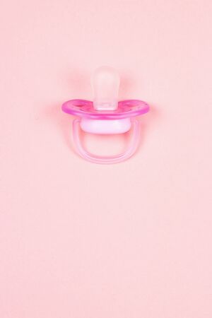 Pink baby pacifier, dummy with rubber nipple on pink background. Flat lay. Top view.の写真素材