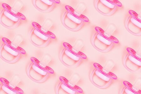 Pattern pink baby pacifiers, dummy with rubber nipple on pink background. Flat lay. Top view.の写真素材