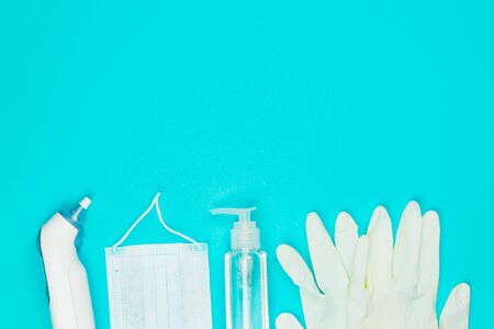 Medical mask, thermometer, white latex gloves and hand sanitizer gel on blue background. Coronavirus protection. Top view. Flat lay.の写真素材