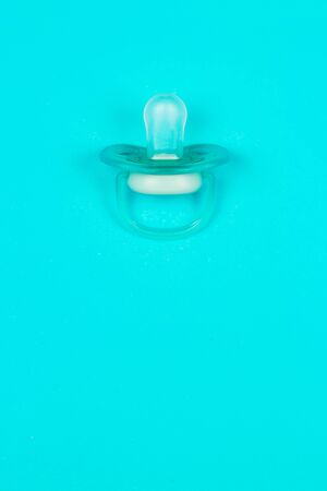 Blue baby pacifier, dummy with rubber nipple on blue background. Flat lay. Top view.