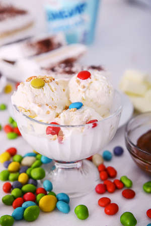 delicious vanilla ice cream in the beads lies in a glass bowl and sprinkle with colored candyの写真素材