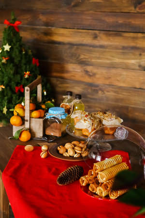new years table with lemonade and cakes in christmas, mugs and peanuts with condensed milkの写真素材