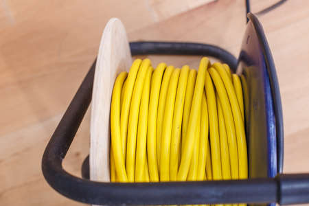 Yellow electric wire extension cord on the reelの写真素材