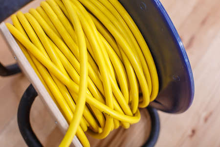 Yellow electric wire extension cord on the reelの写真素材