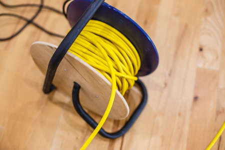 Yellow electric wire extension cord on the reel