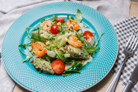 Homemade salad of seasonal greens and herbs with shrimps and guacamole with cherry tomatoes. Cooking at home and food styling.の写真素材