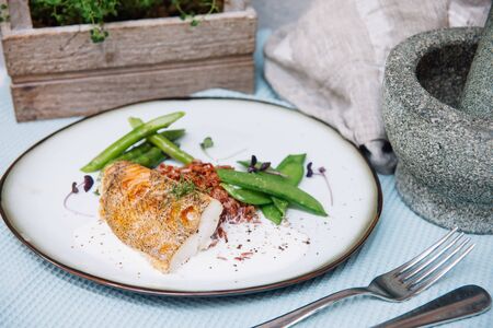 Halibut white fish in coconut sauce with ruby rice and blanched asparagusの写真素材