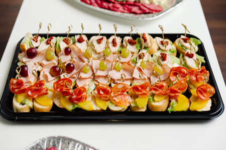 catering delivery tray appetizers canapÃ©s on a skewer. plastic food delivery tray.の写真素材