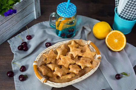 Star-shaped puff pastry cookies in a wicker basket. Cute rustic style. Summer seasonal fruits and berries.の写真素材