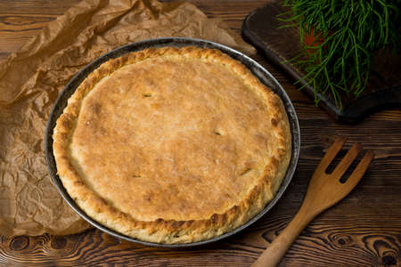 Closed cabbage pie made with yeast dough on a metal baking sheet. Traditional Russian cuisine.の写真素材