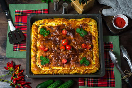 A square meat pie on an iron tray. Greased with butter, sprinkled with pepper and salt. country style. Cooked at home.の写真素材
